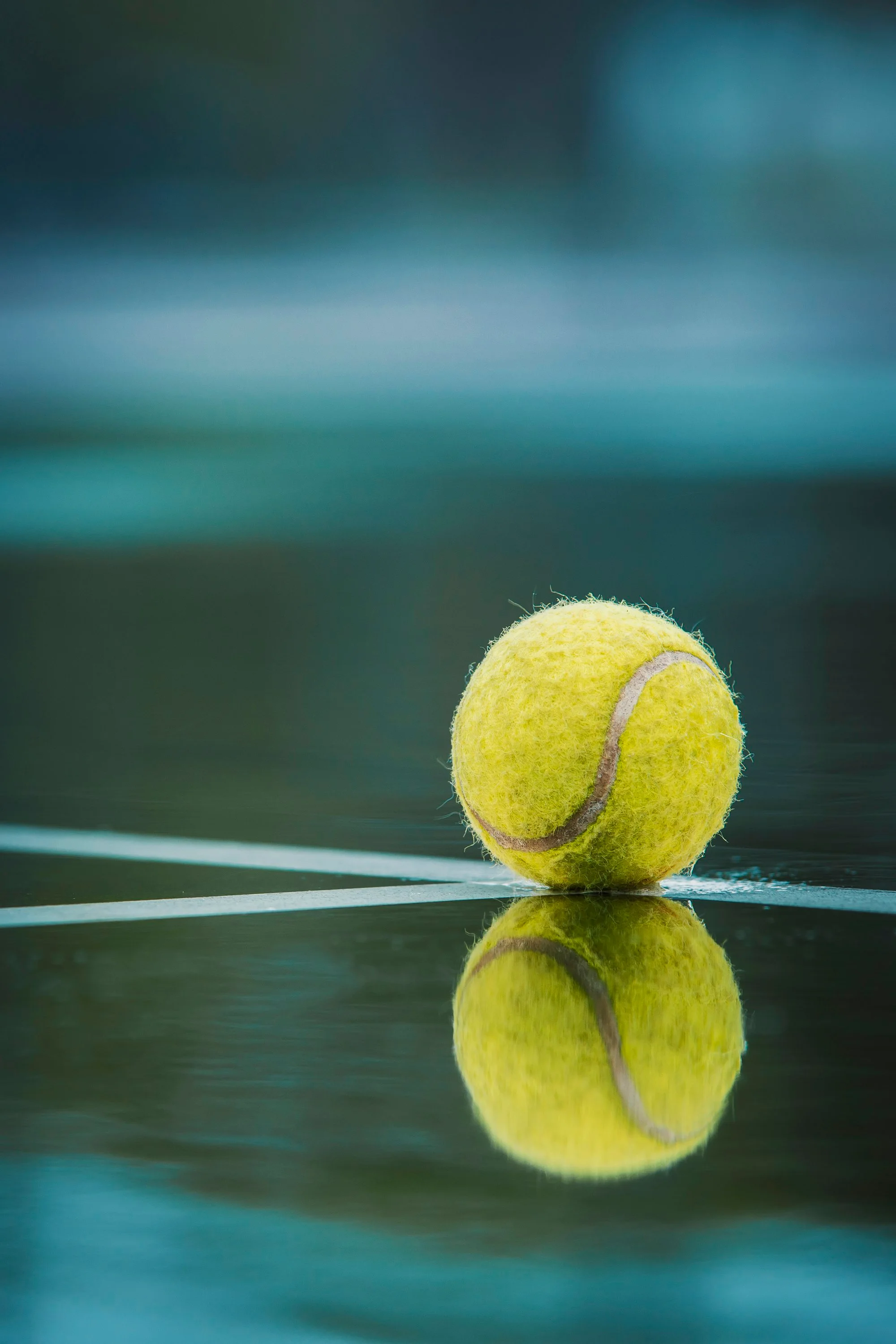 A tennis ball sitting on top of a tennis court